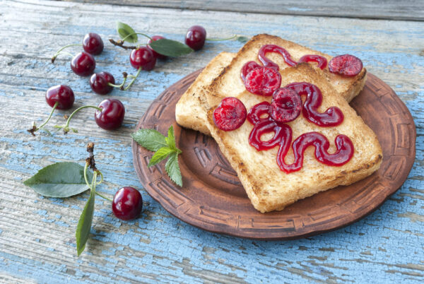 Toast with cherry jam on a wooden table